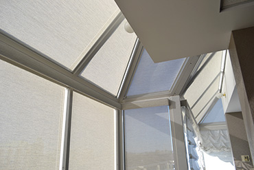 Sloped window panels required triangular and trapezoidal-shaped fixed panels since conventional roller blinds would not work.